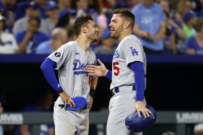 Los Angeles Dodgers' Trea Turner, left, and Freddie Freeman (5) talk during a Kansas City Royals pitching change