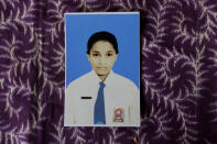 In this Oct. 22, 2018, photo, a photograph of Orance Faot dressed in her school uniform rests on a table in O'of Village in West Timor, Indonesia. Orance's family says she was lured from their house by her own cousin, and is believed to have been trafficked to Malaysia. Her family has not heard from her in four years. (AP Photo/Tatan Syuflana)