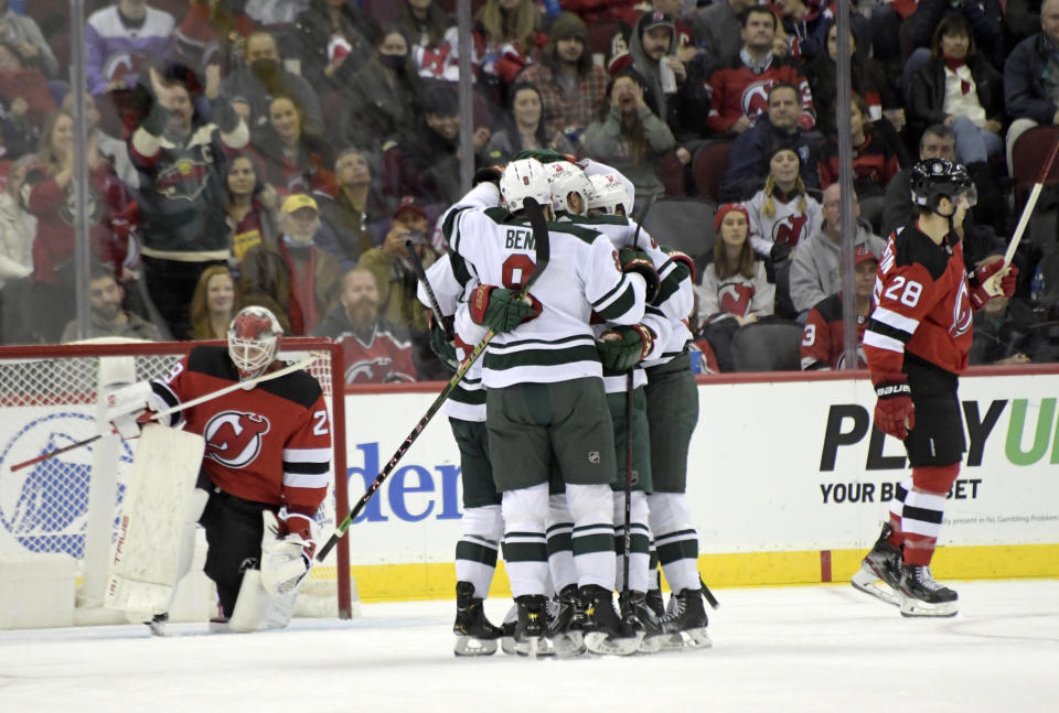 Minnesota Wild right wing Ryan Hartman (38) is surrounded by teammates after scoring a goal against New Jersey Devils goaltender Mackenzie Blackwood, left, during the first period of an NHL hockey game Wednesday, Nov. 24, 2021, in Newark, N.J. (AP Photo/Bill Kostroun)