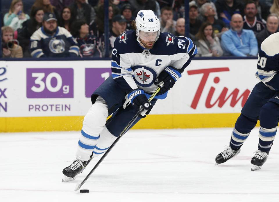 FILE - In this Jan. 22, 2020, file photo, Winnipeg Jets' Blake Wheeler plays against the Columbus Blue Jackets during an NHL hockey game in Columbus, Ohio. Wheeler and the Winnipeg Jets would have been on the road last week, trying to make a final push for the playoffs had the National Hockey League season not been called off because of the pandemic. Now the seven-time All-Star forward is home for dinner each night with his family. (AP Photo/Jay LaPrete, File)