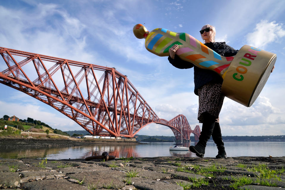 <p>Fiona McGarva holds one of the sculptures from the art installation Gratitude at The Forth Bridge at North Queensferry, ahead of going on display just outside of Edinburgh at Newhailes House and Gardens from Friday 17th September. The public art installation pays tribute to NHS staff and all key workers for their ongoing courage and dedication during the Covid-19 pandemic. Picture date: Wednesday September 15, 2021.</p>
