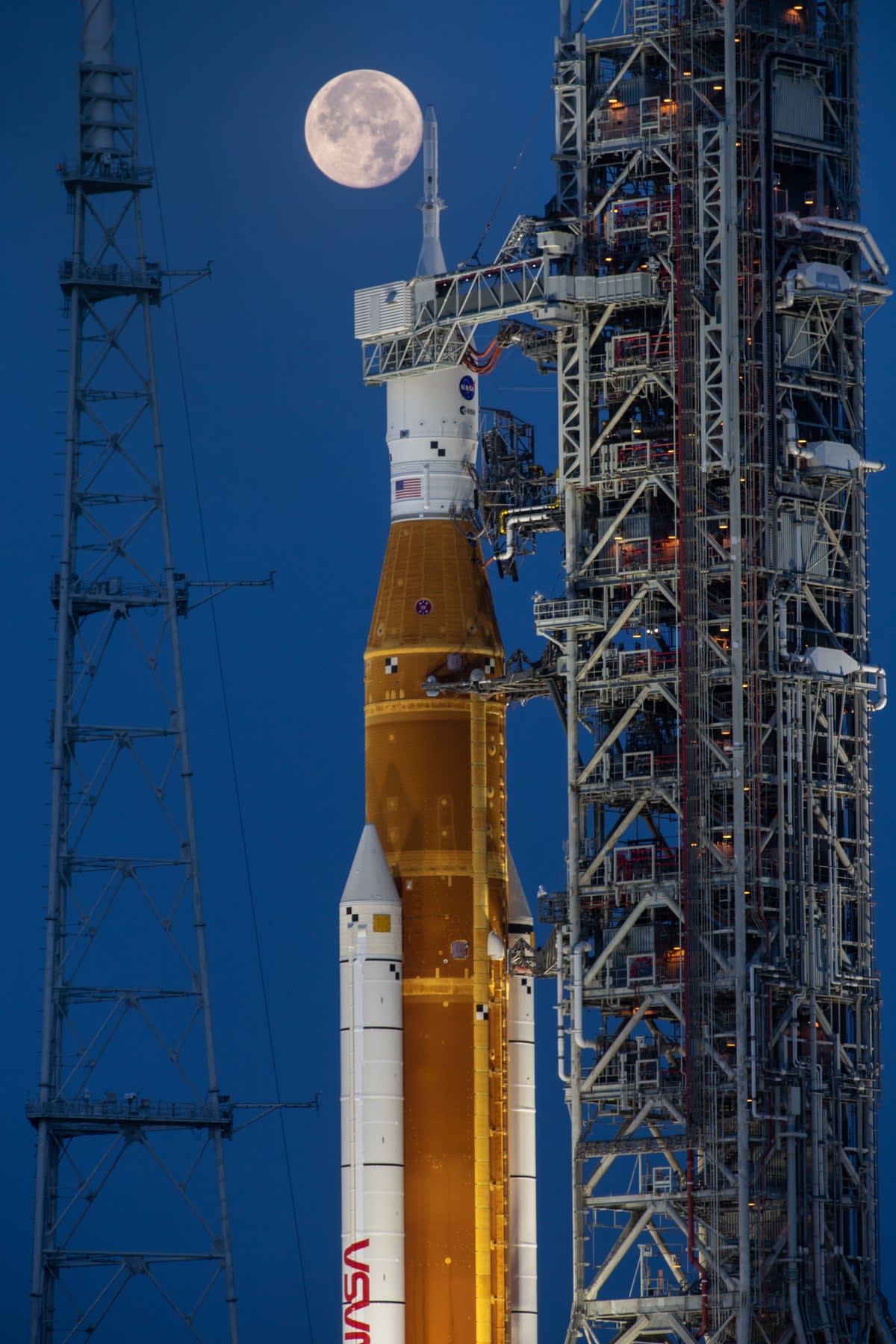 Nasa’s SLS Moon rocket and the Orion spacecraft on the launch pad beneath a full Moon (NASA/Cory Huston)