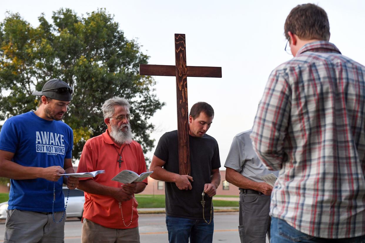 Cole Grotewold holds a wooden cross while praying with members of Jericho Wall, an all-male anti-abortion prayer group, outside Planned Parenthood on Tuesday, Sept. 28, 2021, in Sioux Falls.