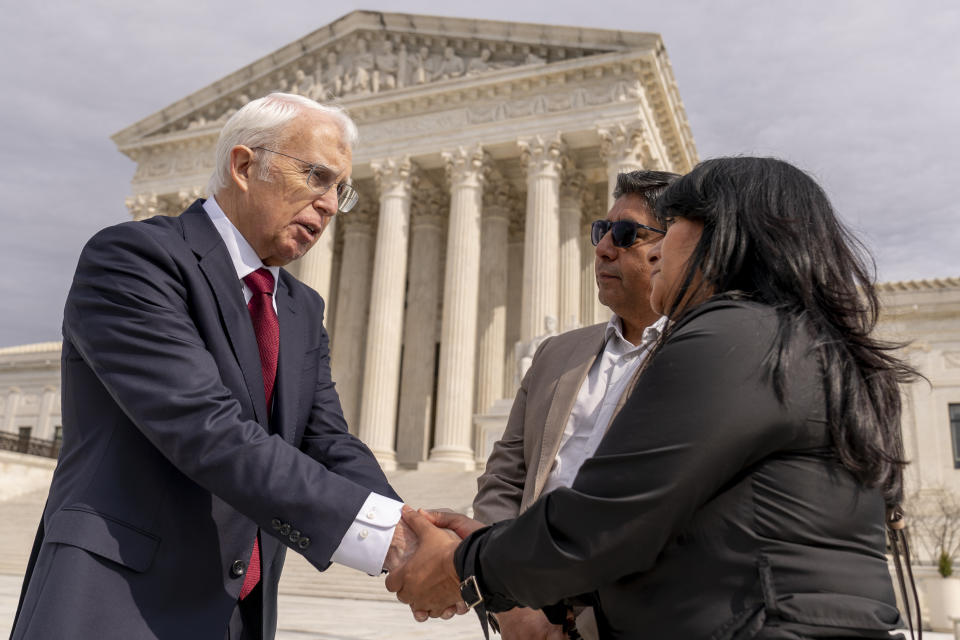 Attorney Eric Schnapper, left, talks with Beatriz Gonzalez, right, the mother of 23-year-old Nohemi Gonzalez, a student killed in the Paris terrorist attacks, and stepfather Jose Hernandez, second from right, in front of the Supreme Court, Wednesday, Feb. 22, 2023 in Washington, after the Supreme Court heard oral arguments in Twitter v. Taamneh today which will decide whether social media companies can be sued for aiding and abetting a specific act of international terrorism when the platforms have hosted user content that expresses general support for the group behind the violence without referring to the specific terrorist act in question. (AP Photo/Andrew Harnik)