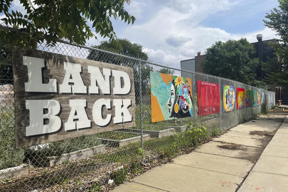 Art adorns the perimeter of First Nations Garden in Chicago, on Aug. 3, 2022. First Nations is a community garden established in the spring of 2019 that hosts many local traditional Indigenous crops including prairie sage, sweetgrass and strawberries. (Claire Savage/Report for America via AP)