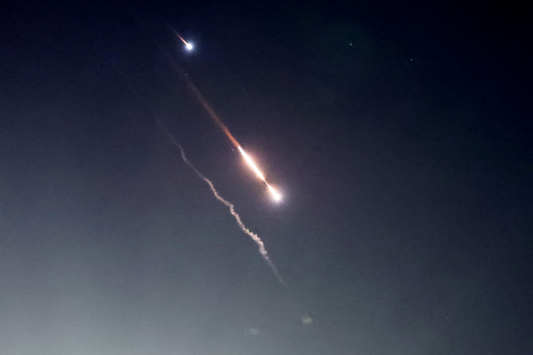 Objects are seen in the sky above Jerusalem after Iran launched drones and missiles toward Israel on Saturday. (Ronen Zvulun/Reuters)