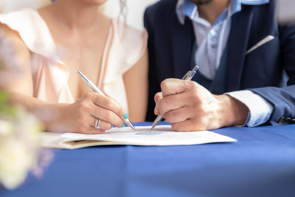 A married couple signing a paper together