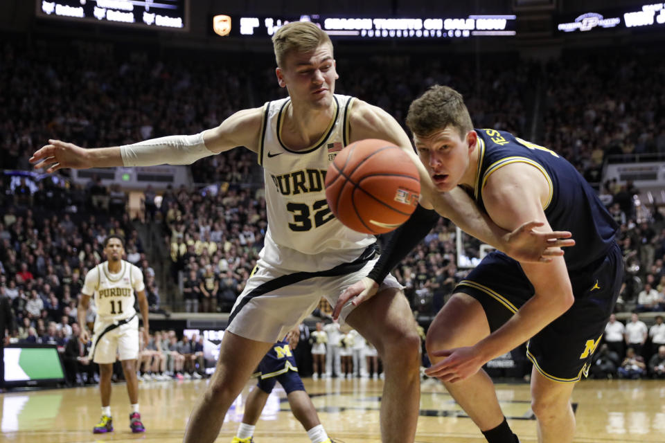 Purdue center Matt Haarms (32) and Michigan center Jon Teske (15) go for a loose ball during the second half of an NCAA college basketball game in West Lafayette, Ind., Saturday, Feb. 22, 2020. (AP Photo/Michael Conroy)