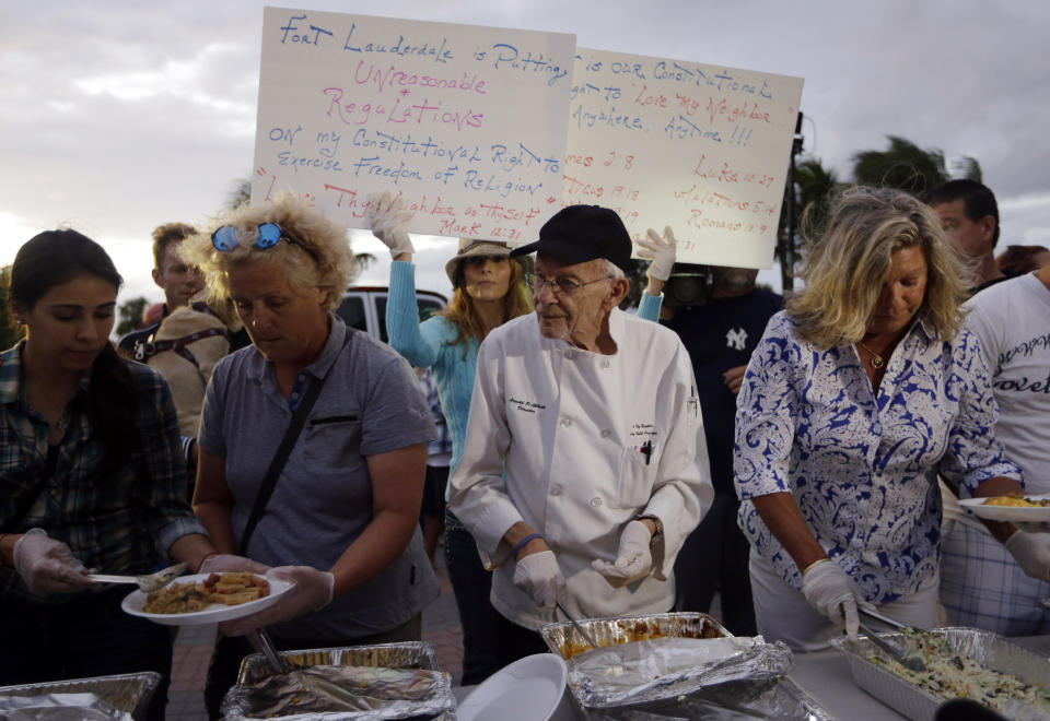 Arnold Abbott, de 90 años, director del grupo sin fines de lucro Love Thy Neighbor Inc., al centro, sirve comida a desamparados. (Foto AP/Lynne Sladky)