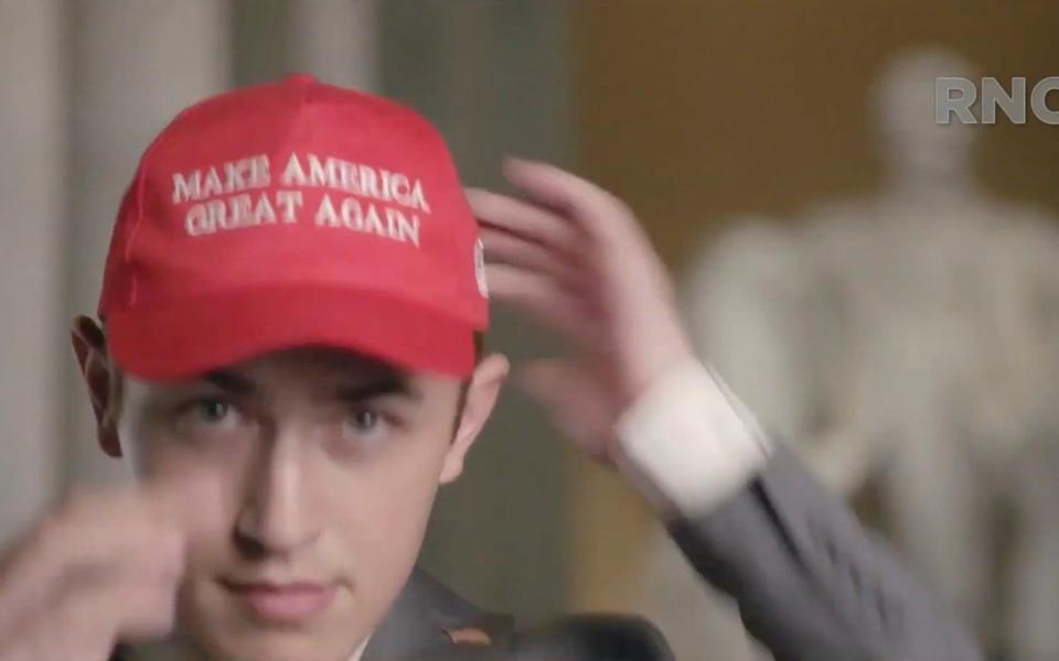 Nicholas Sandmann puts on a Make America Great Again hat while he speaks by video feed - via REUTERS