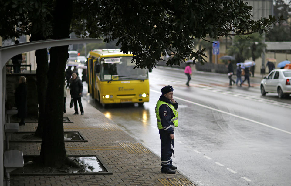 A police officer patrols at a bus stop, Wednesday, Jan. 29, 2014, in Sochi, Russia, home of the upcoming 2014 Winter Olympics. (AP Photo/David Goldman)