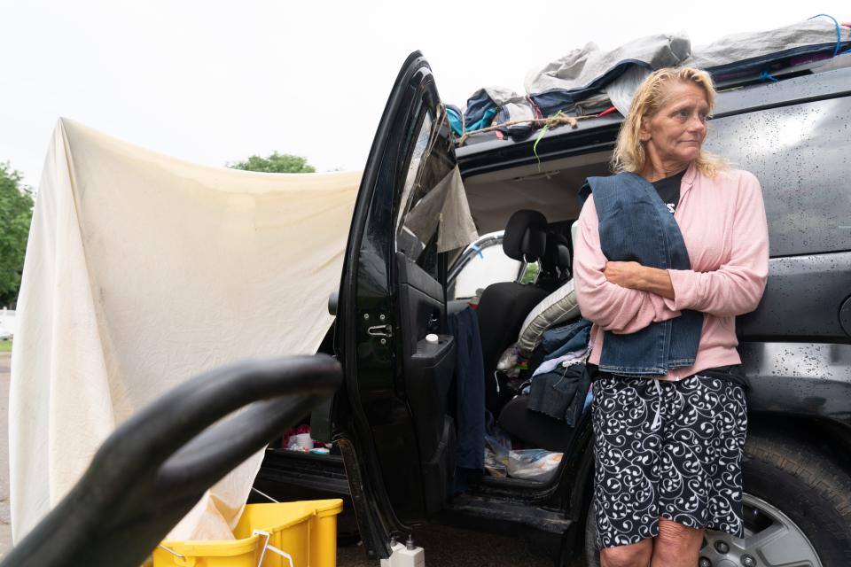 Mary Schierkolk-Ames takes a break from talking about her life Friday while standing in front of her Jeep, in which she lives.