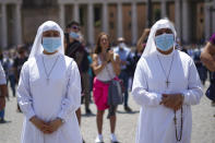 Nuns listen as Pope Francis delivers his blessing as he recites the Angelus noon prayer from the window of his studio overlooking St.Peter's Square, at the Vatican, Sunday, June 7, 2020. Pope Francis is cautioning people in countries emerging from lockdown to keep following authorities’ rules for COVID-19 contagion containment. Says Francis: “Be careful, don’t cry victory, don’t cry victory too soon.” (AP Photo/Andrew Medichini)