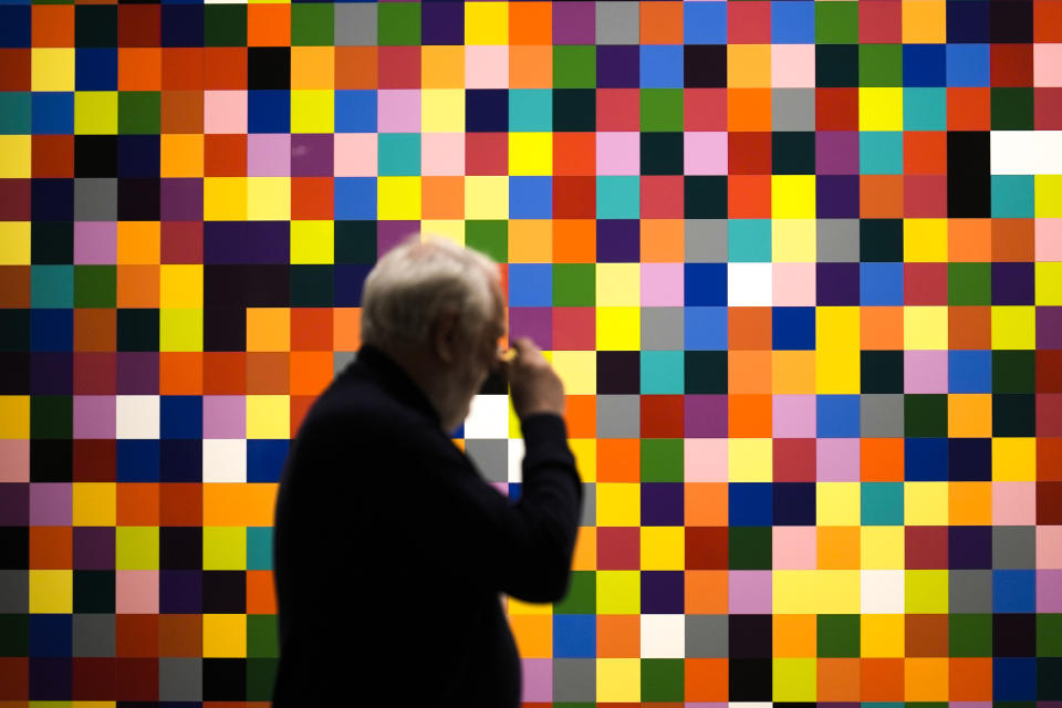 People looks at painting '4900 Colours (excerpt)' in a new exhibition with art works of German artist Gerhard Richter at the New National Gallery in Berlin, Germany, Friday, March 31, 2023. Richter's foundation gave on permanent loan 100 works of the artist to the New National Gallery where they will be shown in the permanent exhibition. (AP Photo/Markus Schreiber)