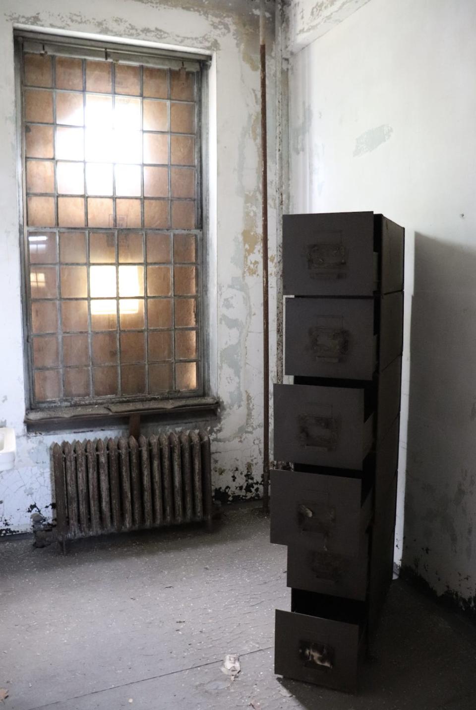 a filing cabinet at the ellis island hospital with drawers open