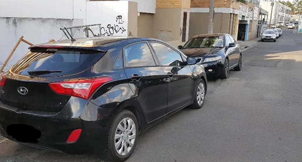 Two cars parked head-to-head in a NSW laneway. 