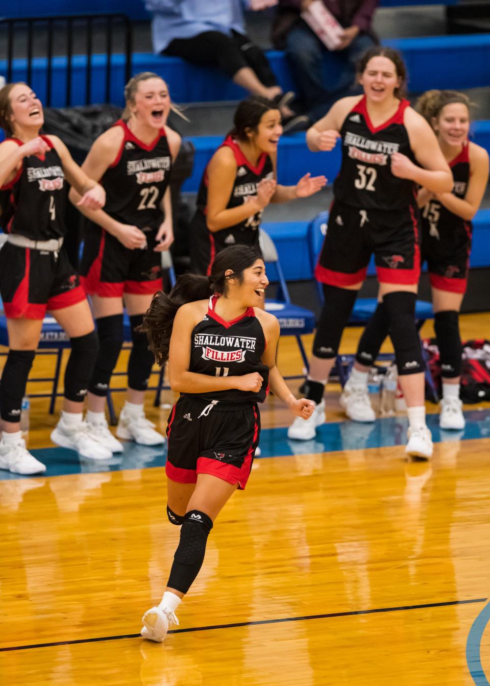Shallowater’s bench celebrates after a made shot by Avery Velasquez (11) against Estacado on Tuesday, Nov. 30, 2021, at Estacado High School in Lubbock, Texas.
