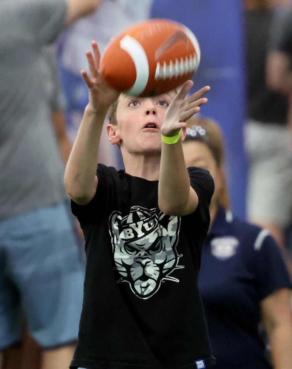 Mason Knight catches a football as BYU holds a party to celebrate their move into the Big 12 Conference with music, games and sports exhibits in Provo on Saturday, July 1, 2023. | Scott G Winterton, Deseret News