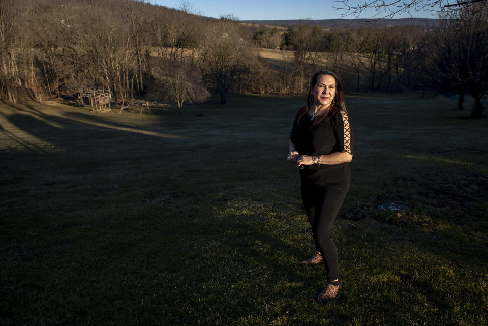 Natalie Abbas walks in her backyard in Myersville, Md., Tuesday, Jan. 19, 2021, the day before the presidential inauguration. As a member of Braver Angels, Abbas, who believes the election was stolen, meets regularly with a neighbor who cheers Biden as the rightful winner, to ponder the greatest challenge facing Biden and American society: how can they find common ground if they no longer exist in the same reality? (AP Photo/Cliff Owen)