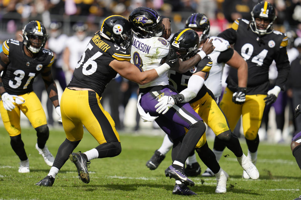 Pittsburgh Steelers linebacker Alex Highsmith (56) and linebacker Cole Holcomb (55) tackle Baltimore Ravens quarterback Lamar Jackson (8) in the second half of an NFL football game in Pittsburgh, Sunday, Oct. 8, 2023. (AP Photo/Gene J. Puskar)