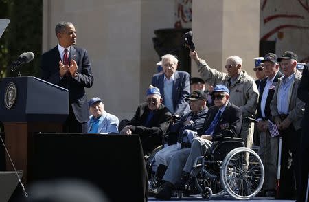 A veteran stands and holds out his hat as U.S. President Barack Obama applauds those who served, during the 70th French-American Commemoration D-Day Ceremony at the Normandy American Cemetery and Memorial in Colleville-sur-Mer June 6, 2014. REUTERS/Kevin Lamarque