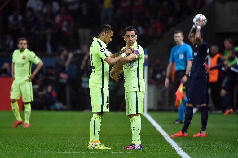 Barcelona's Brazilian forward Neymar da Silva Santos Junior (L) puts the captain armband on Barcelona's midfielder Xavi Hernandez during the UEFA Champions league quarter-final first leg football match PSG vs FC Barcelona in Paris on April 15, 2015