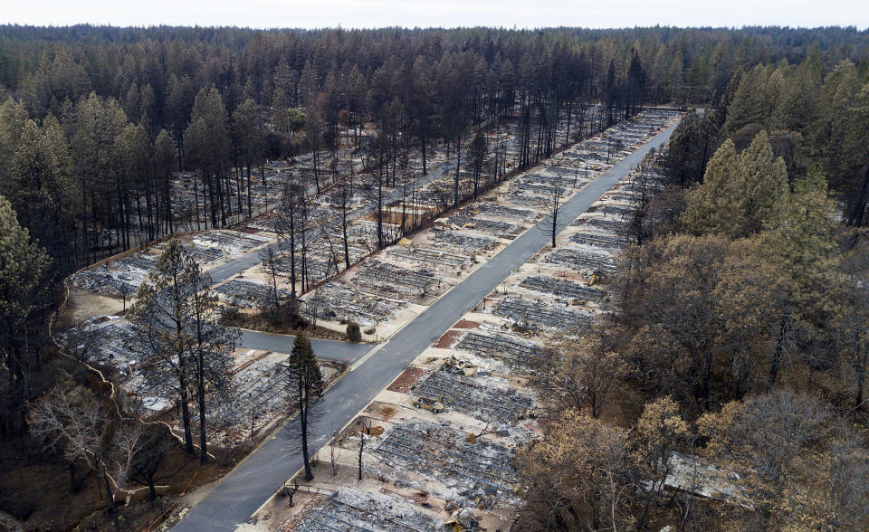 FILE - In this Dec. 3, 2018, file photo, homes leveled by the Camp Fire line the Ridgewood Mobile Home Park retirement community in Paradise, Calif. Pacific Gas and Electric says it has reached a $13.5 billion settlement that will resolve all major claims related to devastating wildfires blamed on its outdated equipment and negligence. The settlement, which the utility says was reached Friday, Dec. 6, 2019, still requires court approval. (AP Photo/Noah Berger, File)