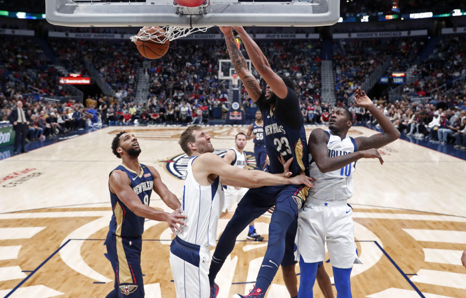 New Orleans Pelicans forward Anthony Davis (23) dunks over Dallas Mavericks forwards Dorian Finney-Smith (10) and Dirk Nowitzki during the first half of an NBA basketball game in New Orleans, Friday, Dec. 28, 2018. (AP Photo/Gerald Herbert)