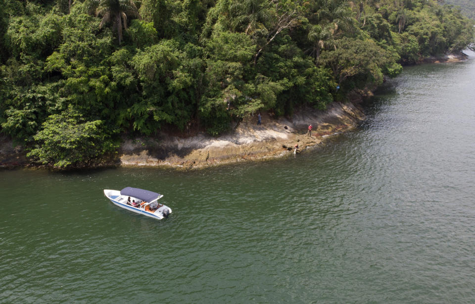 A boat belonging to Animal Heart Protectors is anchored off Furtada Island, popularly known as “Island of the Cats,” where they deliver food and water to the cats in Mangaratiba, Brazil, Tuesday, Oct. 13, 2020. Volunteers are working to ensure the stray and feral cats living off the coast of Brazil have enough food after fishermen saw the animals eating others' corpses, an unexpected consequence of the coronavirus pandemic after restrictions forced people to quarantine, sunk tourism, shut restaurants that dish up seafood and sharply cut down boat traffic around the island. (AP Photo/Mario Lobao)