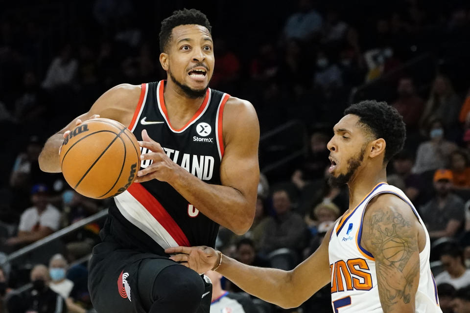 Portland Trail Blazers guard CJ McCollum drives as Phoenix Suns guard Cameron Payne, right, defends during the first half of a preseason NBA basketball game, Wednesday, Oct. 13, 2021, in Phoenix. (AP Photo/Matt York)