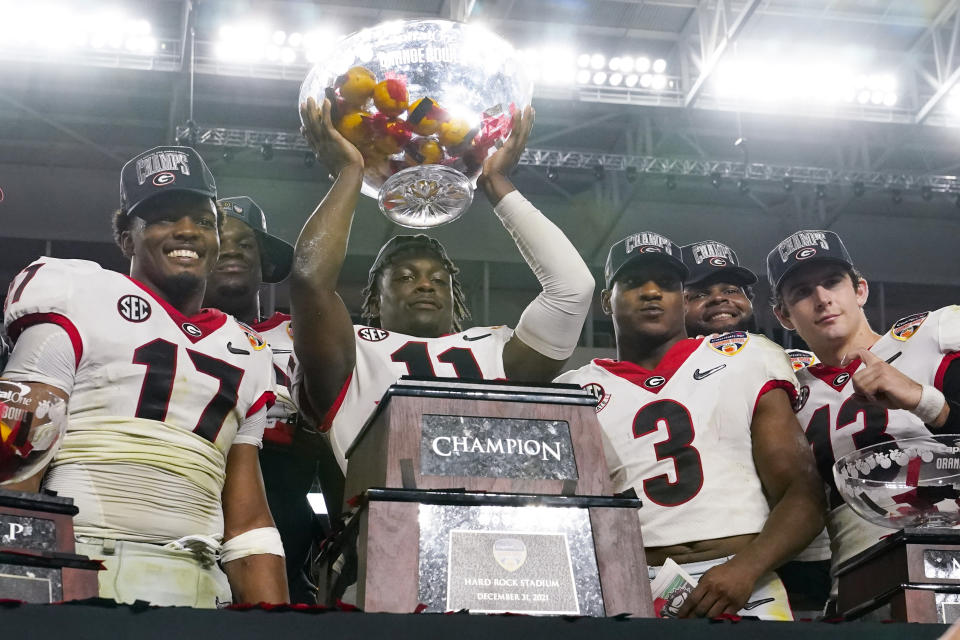 Georgia defensive back Derion Kendrick holds up the trophy after their win against Michigan in the Orange Bowl NCAA College Football Playoff semifinal game, Friday, Dec. 31, 2021, in Miami Gardens, Fla. Georgia won 34-11. (AP Photo/Lynne Sladky)