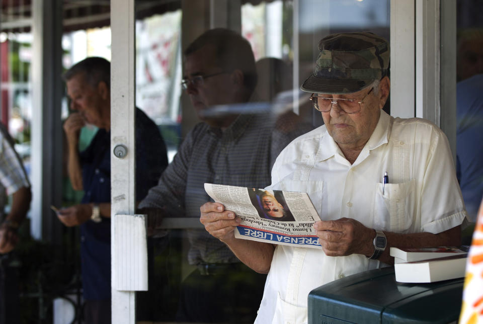 Nino Diaz reads a Spanish language newspaper at a Cuban cafe in Miami's Little Havana section, Tuesday, Oct. 16, 2012 about the news of the day. The Cuban government has announced that it will no longer require islanders to apply for an exit visa, eliminating a much-loathed bureaucratic procedure that has been a major impediment for many seeking to travel overseas for more than a half-century. A notice published in Communist Party newspaper Granma said the change takes effect Jan. 14, and beginning on that date islanders will only have to show their passport and a visa from the country they are traveling to. It is the most significant advance this year in President Raul Castro's five-year plan of reform that has already seen the legalization of home and car sales and a big increase in the number of Cubans owning private businesses.(AP Photo/J Pat Carter)