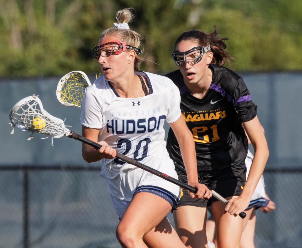Hudson's Ryan St. Pierre brings the ball upfield with St. Joseph's Academy's Elsie Larson defending during a Division I girls lacrosse regional final Friday night in Hudson.