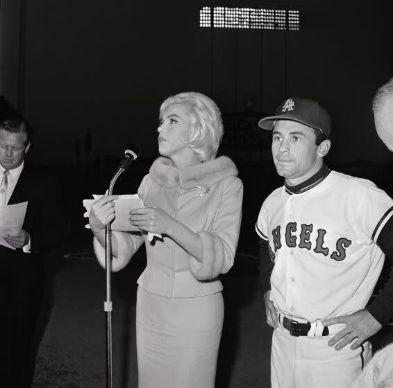 (Original Caption) Actress Marilyn Monroe runs into the field at Chavez Ravine accompanied by Los Angeles Angel