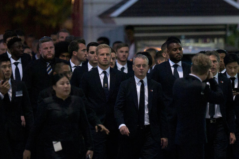 In this Sunday, Nov. 4, 2018, file photo, players and officials of the English Premier League club Leicester City arrive at a Buddhist temple to participate in the funeral rituals of Vichai Srivaddhanaprabha in Bangkok, Thailand. An elaborate funeral began Saturday for Thai billionaire and Leicester City owner Vichai Srivaddhanaprabha, who died last week when his helicopter crashed in a parking lot next to the English Premier League club's stadium. (AP Photo/Gemunu Amarasinghe, File)