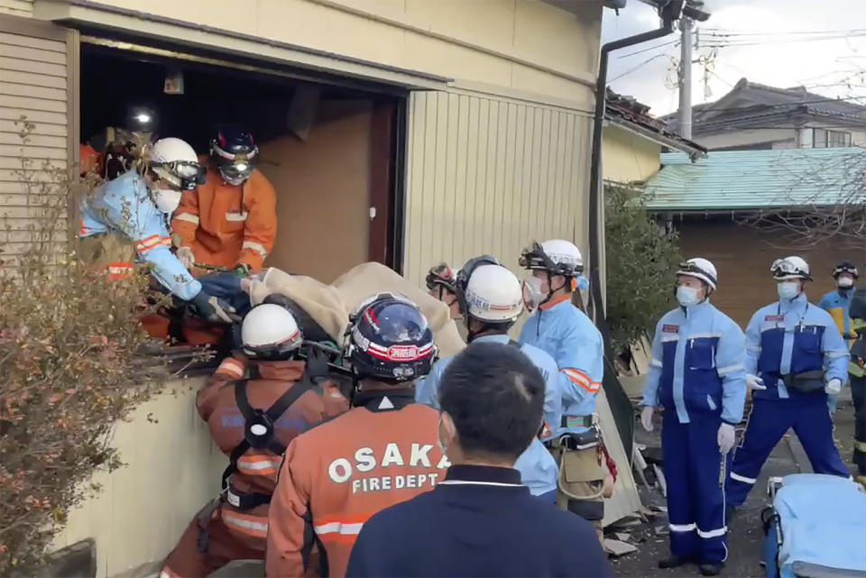 En esta imagen, tomada de un video distribuido por el Departamento de Bomberos de Osaka, una mujer es sacada en camilla tras ser encontrada bajo su casa destruida 72 horas después de un potente sismo en Wajima, en la prefectura de Ishikawa, Japón, el 4 de enero de 2024. (Departamento de Bomberos de Osaka vía AP)