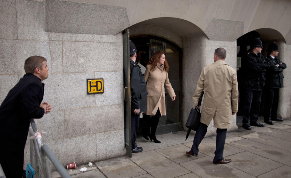 British actor John Alford, left, watches as Rebekah Brooks, center, the former chief of News Corp.'s British operations leaves after appearing in her phone hacking case at the Old Bailey court in the City of London, Wednesday, Sept. 26, 2012. Brooks and Coulson appeared in London’s Old Bailey court Wednesday for a hearing along with five other people charged in connection with the phone hacking scandal that originated at the News of the World tabloid and rocked Rupert Murdoch's News Corp. empire. Rebekah Brooks, the former chief of News Corp.'s British newspapers, and Andy Coulson, the ex-communications chief for Prime Minister David Cameron, learned Wednesday that they will face trial next September over allegations linked to phone hacking. (AP Photo/Matt Dunham)