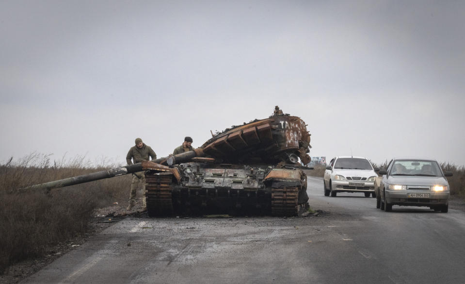 Ukrainian soldiers inspect damaged a Russian tank on a road near the recently retaken village of Kamianka, Kharkiv region, Ukraine, Sunday, Oct. 30, 2022.(AP Photo/Efrem Lukatsky)