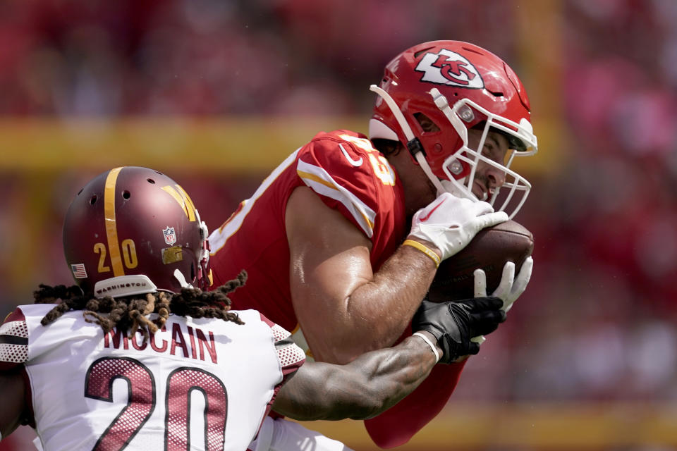 Kansas City Chiefs tight end Noah Gray catches a pass as Washington Commanders safety Bobby McCain (20) defends during the first half of an NFL preseason football game Saturday, Aug. 20, 2022, in Kansas City, Mo. (AP Photo/Charlie Riedel)