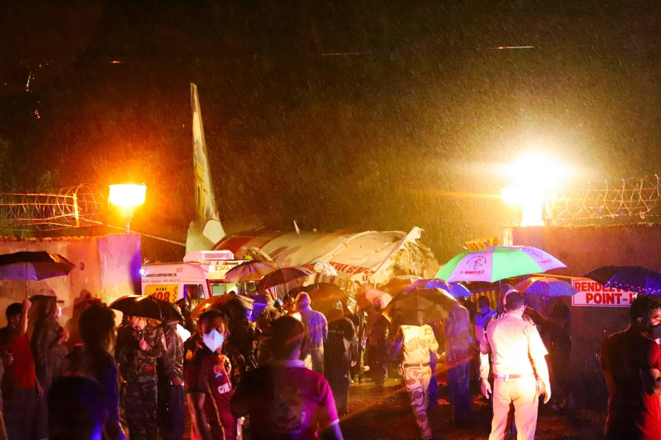 First responders gather around the wreckage of an Air India Express jet, which was carrying more than 190 passengers and crew from Dubai, after it crashed by overshooting the runway at Calicut International Airport in Karipur, Kerala, on August 7, 2020. (Photo by - / AFP) (Photo by -/AFP via Getty Images)