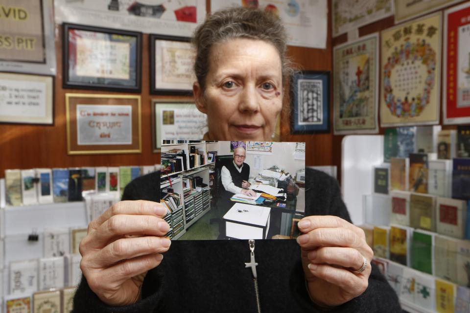 Karen Short, wife of Australian missionary John Short, poses with a photo of her husband inside the Christian Book Room in Hong Kong Wednesday, Feb. 19, 2014. Australian missionary Short went to North Korea in a regular tour group last week with one other person, who returned to China on Tuesday and told the family Short had been questioned and arrested at his Pyongyang hotel on Sunday, according to a statement released by the family. (AP Photo/Kin Cheung)