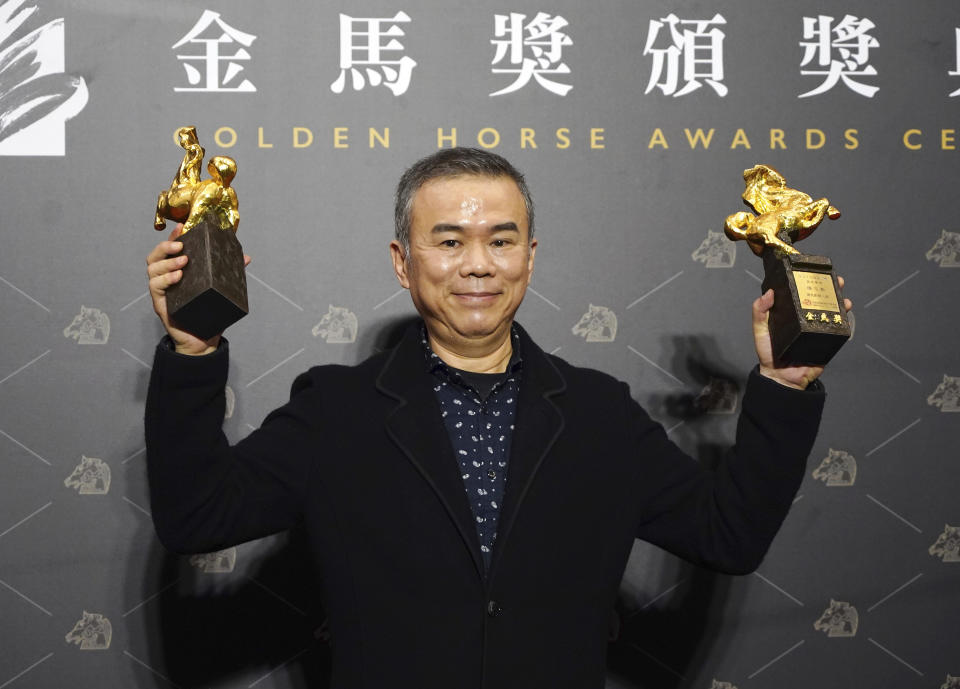 Taiwanese director Chen Yu-hsun holds his awards for Best Director and Best Original Screenplay at the 57th Golden Horse Awards in Taipei, Taiwan, Saturday, Nov. 21, 2020. Chen won for the film "My Missing Valentine" at this year's Golden Horse Awards - one of the Chinese-language film industry's biggest annual events. (AP Photo/Billy Dai)