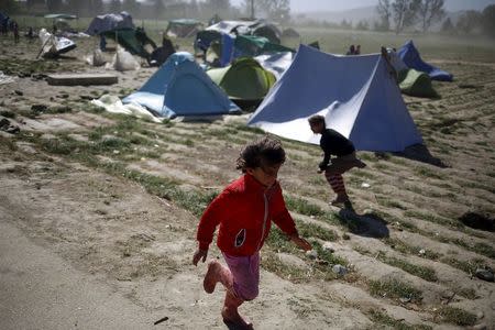 Children run for cover during heavy winds at a makeshift camp for migrants and refugees at the Greek-Macedonian border near the village of Idomeni, Greece, April 20, 2016. REUTERS/Stoyan Nenov