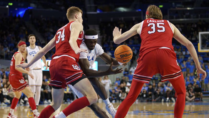 UCLA forward Adem Bona, center, drives against Utah centers Lawson Lovering (34) and Branden Carlson (35) during the second half of an NCAA college basketball game, Sunday, Feb. 18, 2024, in Los Angeles. 