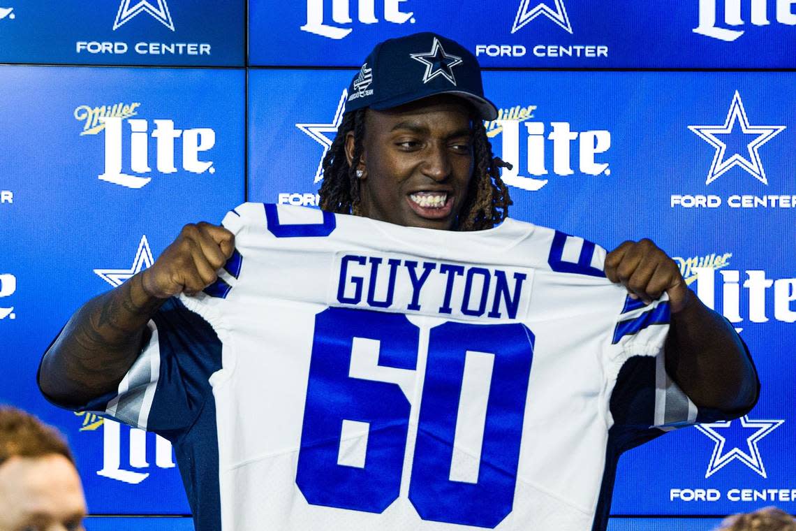 Dallas Cowboys 2024 first round pick Tyler Guyton holds uo his jersey during his introductory press conference at The Star in Frisco on Friday, April 26, 2024.