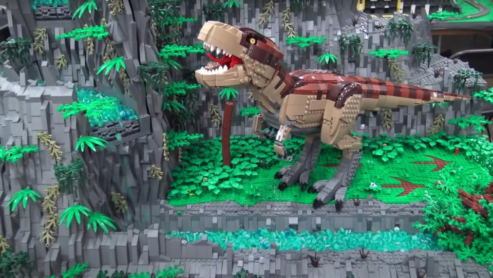 A LEGO build featuring a giant T-rex and working, motorized LEGO waterfall.