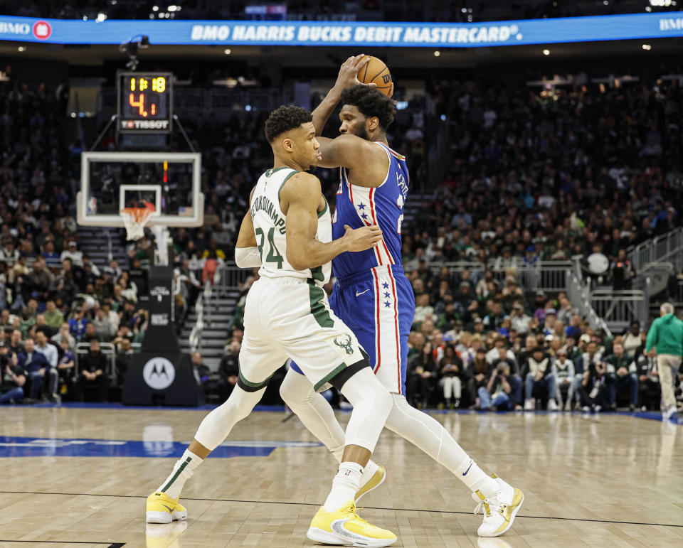 Philadelphia 76ers center Joel Embiid, right, drives against Milwaukee Bucks forward Giannis Antetokounmpo (34) during the first half of an NBA basketball game Sunday, April 2, 2023, in Milwaukee. (AP Photo/Jeffrey Phelps)