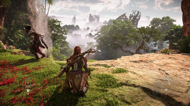 A PS4 screenshot shows Aloy standing on a cliff overlooking an overgrown launch pad. 