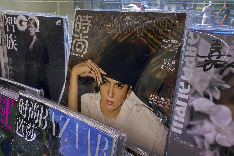 A fashion magazine showing Chinese-Canadian singer Kris Wu, center, on display for sale on a bookshelves at a convenience store in Beijing, Tuesday, July 20, 2021. Kris Wu, has lost endorsement deals with at least 10 brands including Porsche and Louis Vuitton after a teen-ager accused him of having sex with her while she was drunk. (AP Photo/Andy Wong)