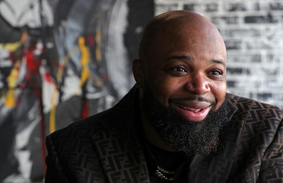 De'Juan Kelker II smiles as he chats during his downtown Akron restaurant's soft opening.